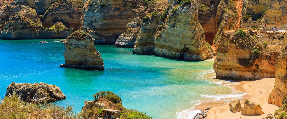View of famous Praia Dona Ana beach with turquoise sea water and cliffs, Portugal