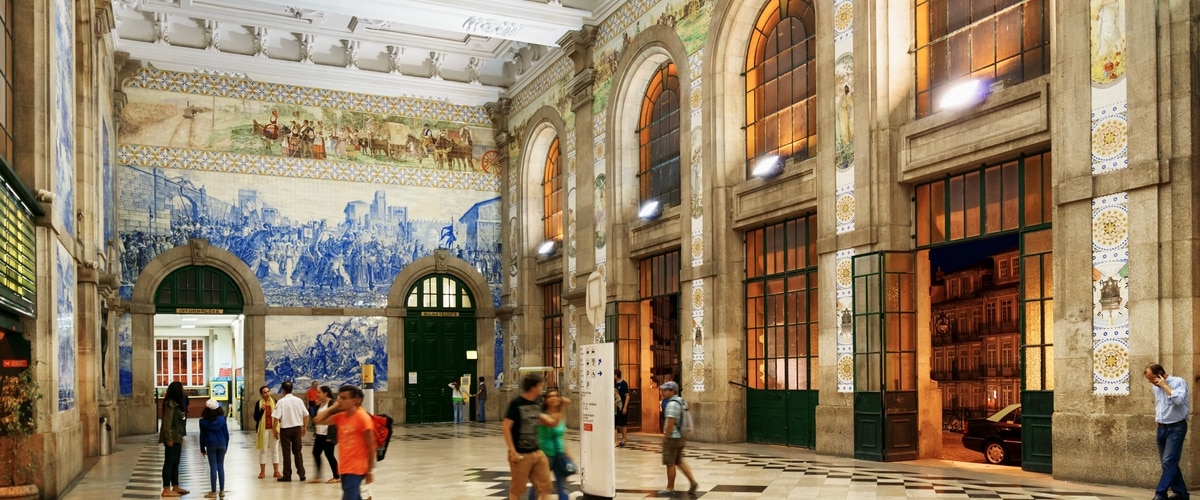 The main hall with azulejos on walls of the Sao Bento Railway Station in Oporto city. The building of station is a popular tourist attraction of Europe.